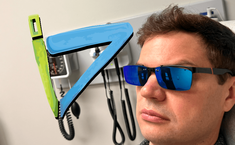David Kolmer sitting in a Doctors office. the I D logo is to the left of his head. a Green lowercase i makes the stem of on uppercase D.